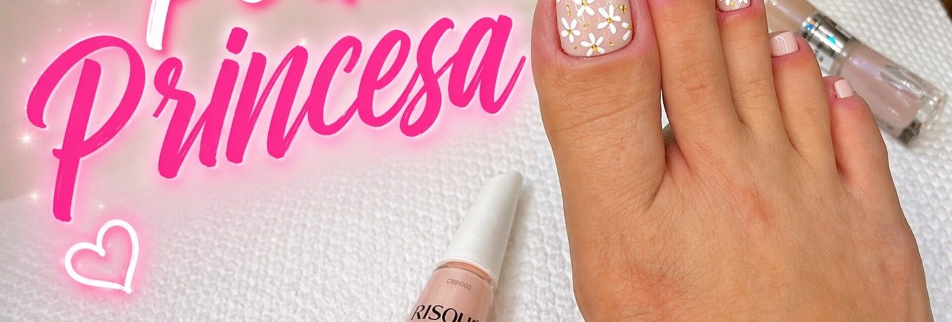 Unhas dos pés em tom nude rosado com florzinhas brancas