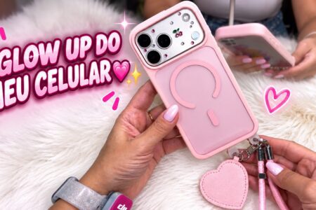 Glow up no celular com capinha rosa, cerejas e acessórios